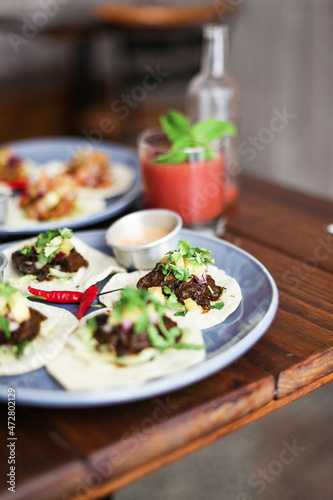 Mexican tacos, red spicy pepper, sauces in a restaurant