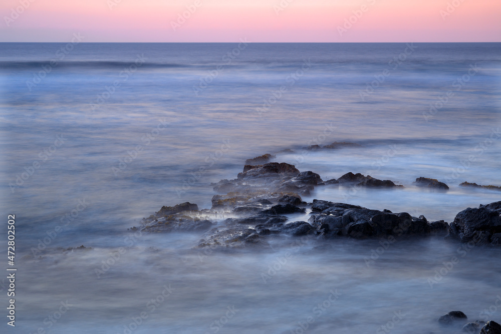 USA, Hawaii, Big Island of Hawaii. Kohanaiki Beach Park, Dawn sky over waves and volcanic rock.