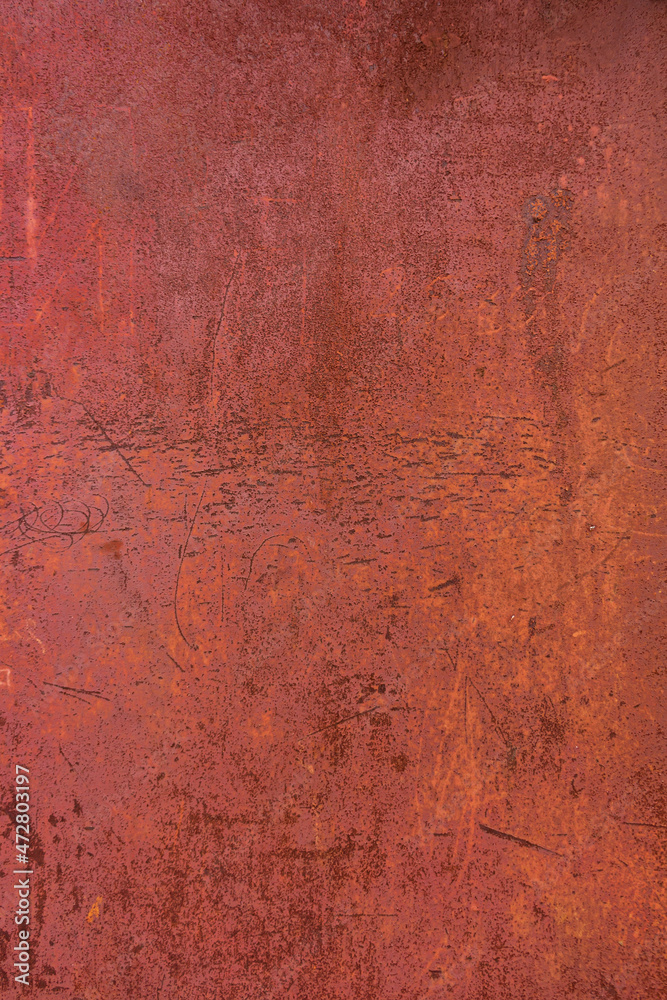 Metallic surface with rusting fencing and crumbling red paint.
