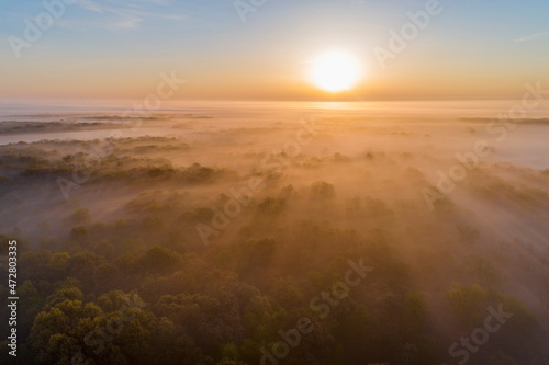Aerial sunrise over forest covered with fog in spring Marion County, Illinois