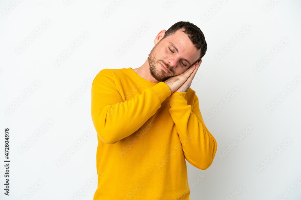 Young Brazilian man isolated on white background making sleep gesture in dorable expression Young Brazilian man isolated on white background making sleep gesture in dorable expression
