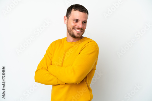 Young Brazilian man isolated on white background with arms crossed and happy