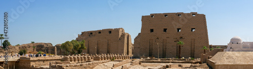 Luxor, Egypt - October 3, 2021: Panoramic view of the Karnak Temple - the temple complex of ancient Egypt. People walk through the alley of sphinxes to the main entrance to the park.
