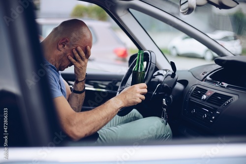 Obraz na płótnie Drunk driver drinking alcohol in car and holding beer bottle w salonie