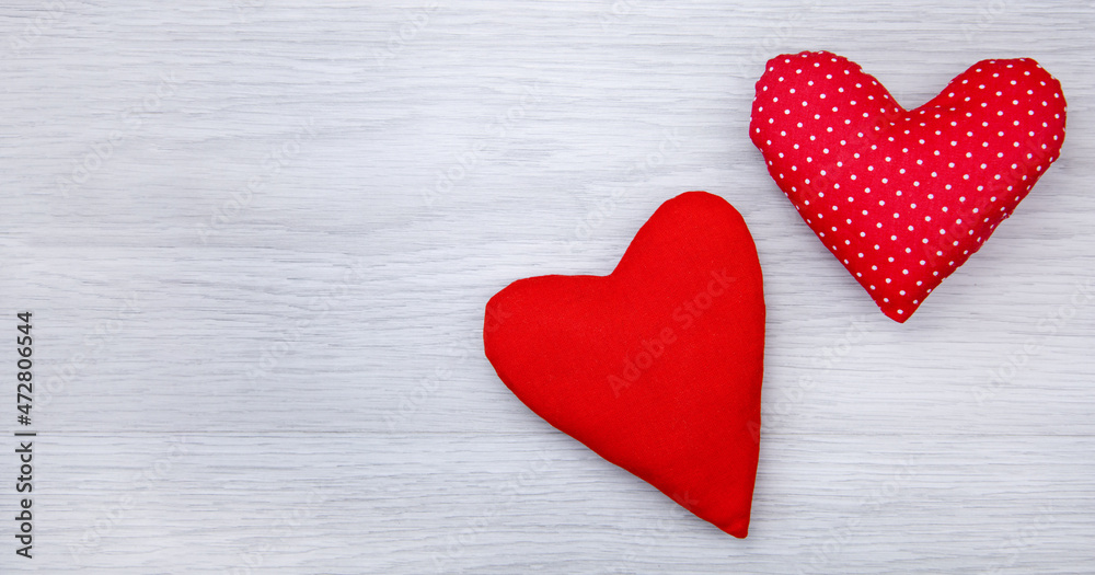 Obraz premium A red heart made of cloth in the hands on a wooden background. Valentine's Day, Mother's Day.The concept of love and celebration.Flat lay