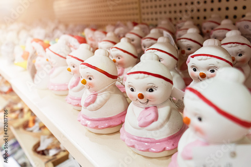 Fototapeta Naklejka Na Ścianę i Meble -  Christmas ceramic toys snowmen stand on a store shelf,
Christmas shopping.
Gifts and toys for decorating the Christmas tree on
Christmas and New Year,
