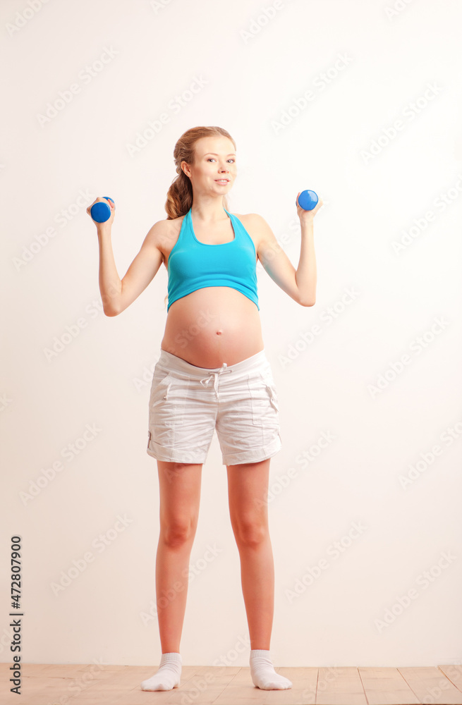 Prenatal exercises. Beautiful pregnant woman exercising with dumbbells. Prenatal exercises. Beautiful pregnant woman exercising with dumbbells.