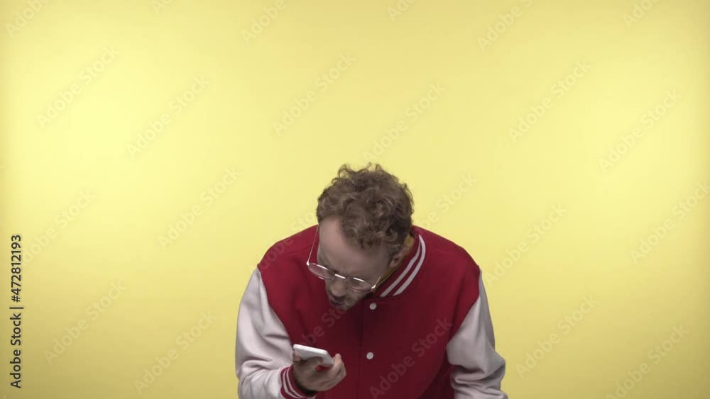angry man screaming on smartphone and putting in pocket on yellow angry man screaming on smartphone and putting in pocket on yellow
