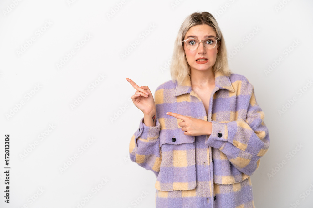 Young caucasian woman isolated on white background frightened and pointing to the side Young caucasian woman isolated on white background frightened and pointing to the side