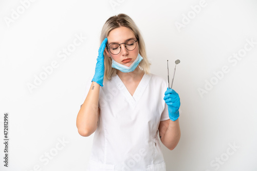 Dentist caucasian woman holding tools isolated on white background with headache