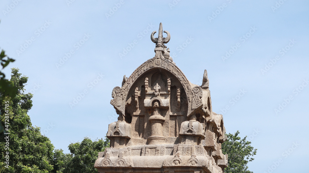 Temple carved in stone. And there are many sculptures in it. Located in a natural background.A side view.