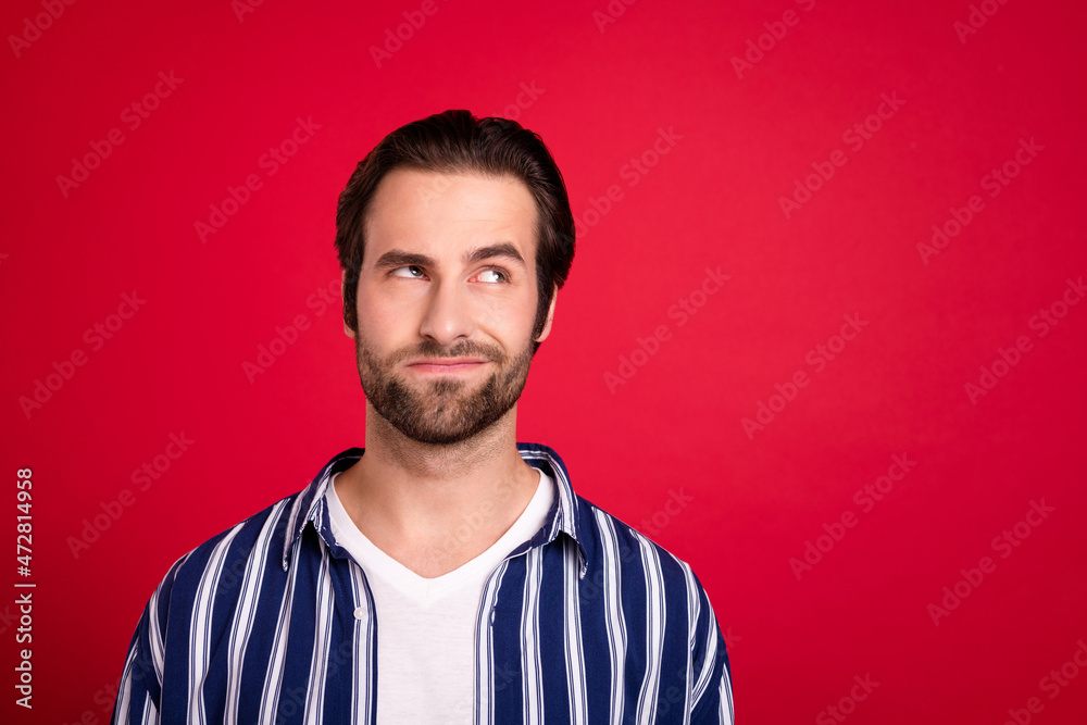Portrait of intersted unaware guy look empty space try decide find answer isolated over bright red color background Portrait of intersted unaware guy look empty space try decide find answer isolated over bright red color background