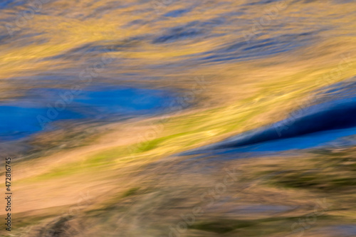 Abstract reflection of blue sky and autumn gold on flowing water, Canary Spring, Mammoth Hot Springs, Yellowstone National Park, Montana, USA