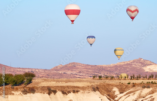 Travel and tourism by Turkey. Famous sightseeing Cappadocia, Anatolia. Beautiful landscape with mountains, caves and baloons in the sky. © luengo_ua
