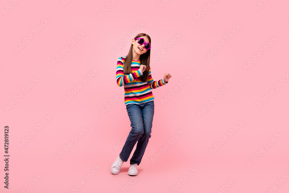 Photo of cute positive small lady enjoy clubbing wear star sunglass striped shirt isolated pink color background