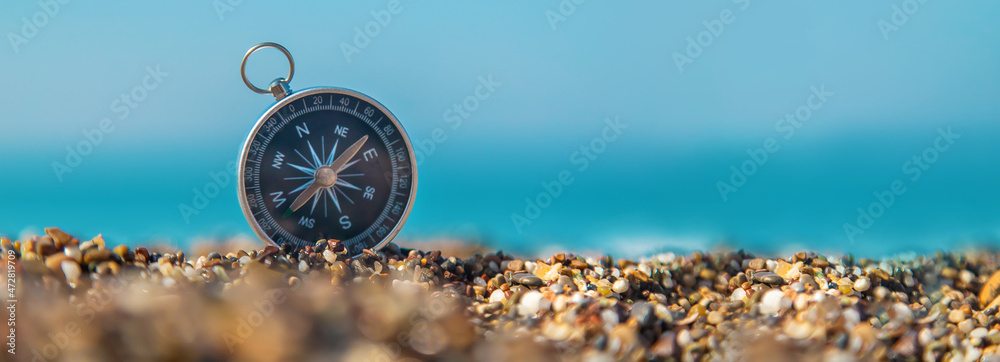 Compass on the sea beach. Selective focus. - obrazy, fototapety, plakaty 
