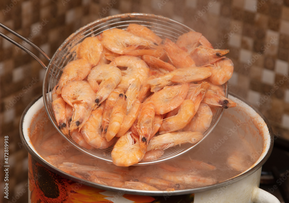 Red shrimps are boiled in a saucepan. Red shrimps are boiled in a saucepan.