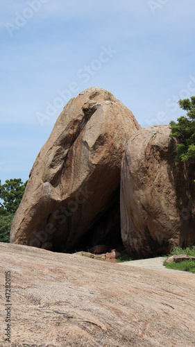 The large rock on the ground is located in the natural background.