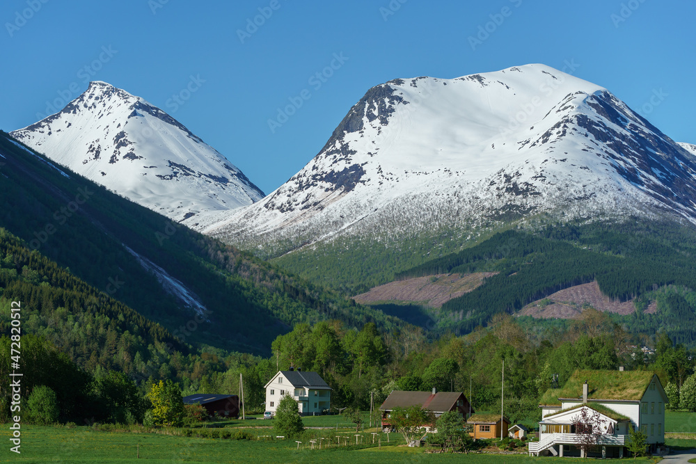 Valldal valley with houses and mountains with snow on.