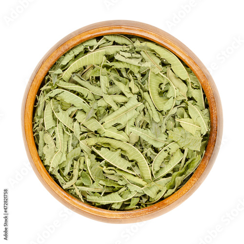 Dried lemon verbena leaves in a wooden bowl. Dry leaves of Aloysia citrodora also known as lemon beebrush. Used as herbal tea, in potpourri, for flavoring food and liqueur and in traditional medicine. photo