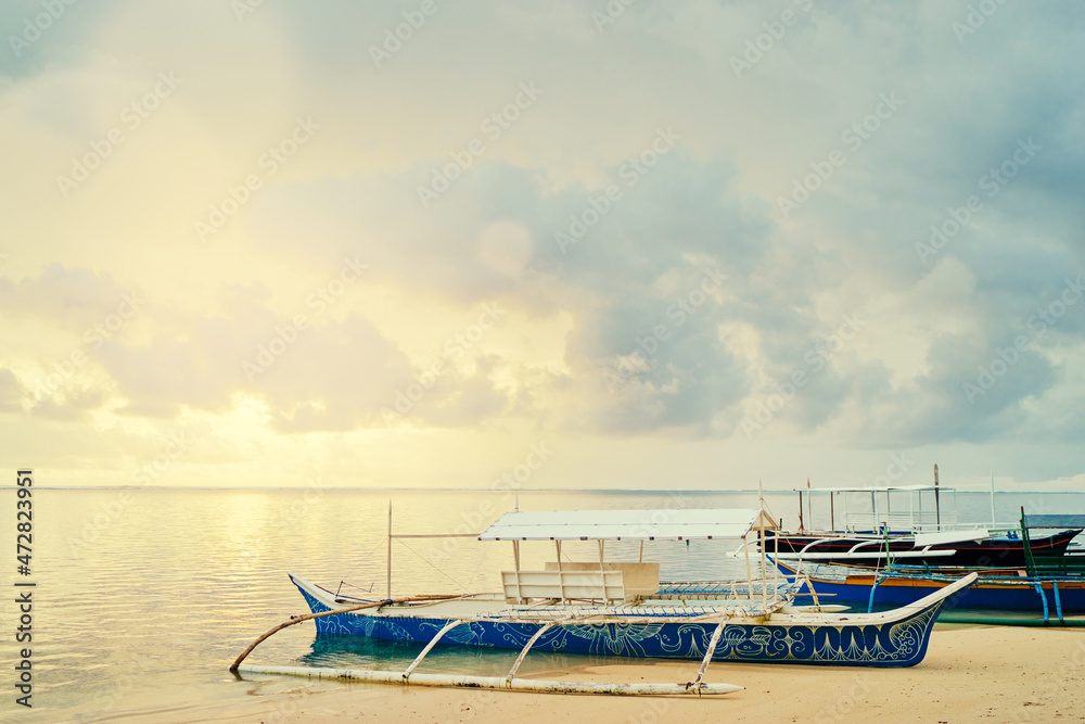 Fototapeta premium Beautiful colorful sunrise on the seashore with fishing boats. Philippines, Siargao Island.