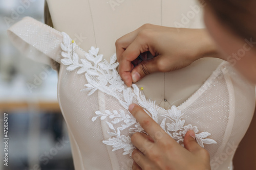 A woman is sewing something and perfecting her ornament.
