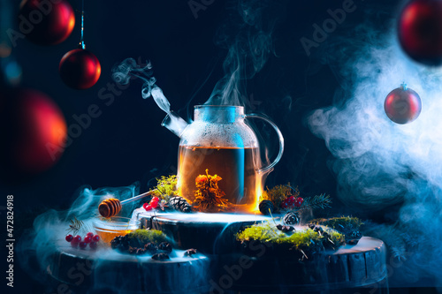 Magic of new year's eve. Tea pot with hot tea on Christmas decorated table. Cozy, happy home holiday atmosphere.