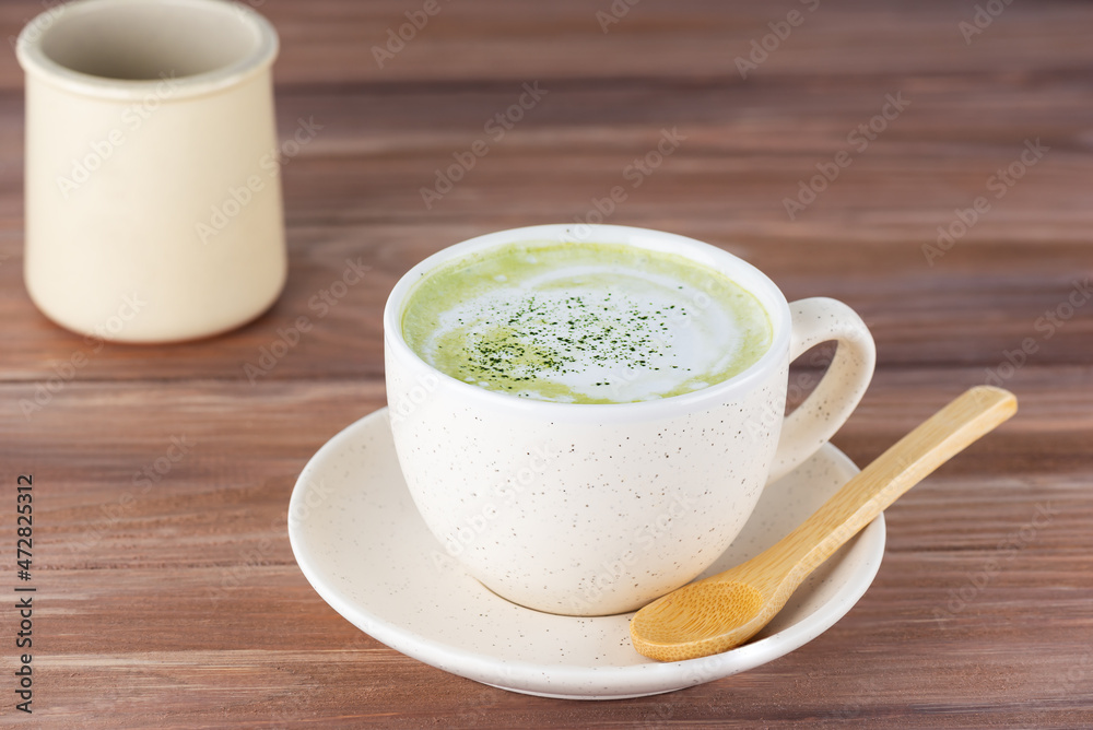 Matcha latte tea in a mug on a wooden table. Matcha latte tea in a mug on a wooden table.