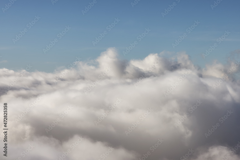 Aerial View from Above the White Puffy Clouds during a sunny day. Taken from Grouse Mountain, North Vancouver, British Columbia, Canada. Aerial View from Above the White Puffy Clouds during a sunny day. Taken from Grouse Mountain, North Vancouver, British Columbia, Canada.