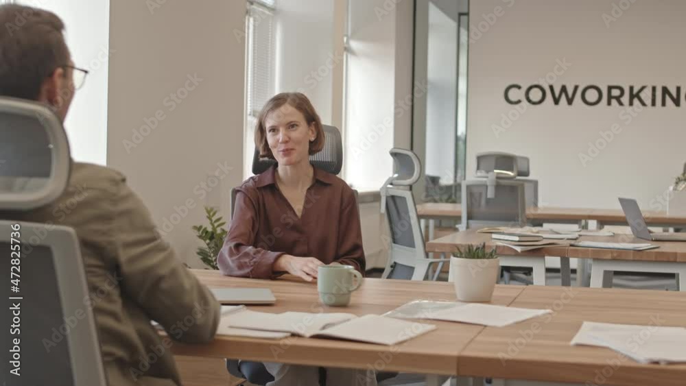 Slowmo shot of happy young woman shaking hand to her employer after getting new job then being taken by her colleague to excursion around office Slowmo shot of happy young woman shaking hand to her employer after getting new job then being taken by her colleague to excursion around office