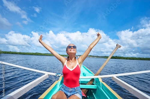 Happy vacation in Philippines. Pretty young woman sailing the sea on traditional boat.
