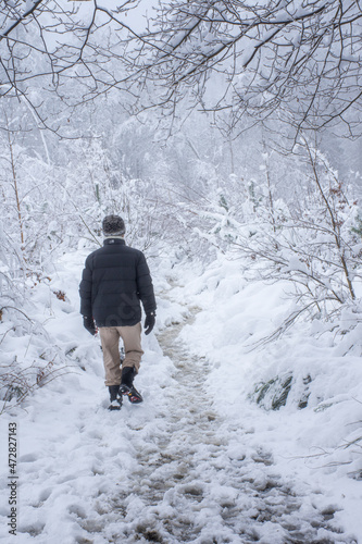  man walking in snowy forest in Belgium