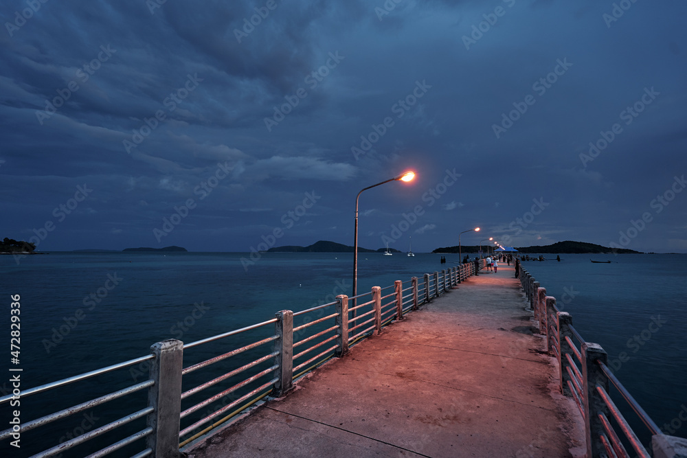 Obraz premium Beautiful sunset landscape with sea, embankment, storm sky and pier.