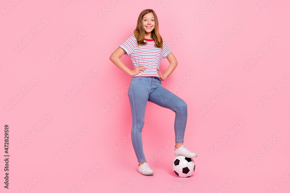 Full body photo of pretty small blond girl play football wear t-shirt jeans footwear isolated on pink background Full body photo of pretty small blond girl play football wear t-shirt jeans footwear isolated on pink background