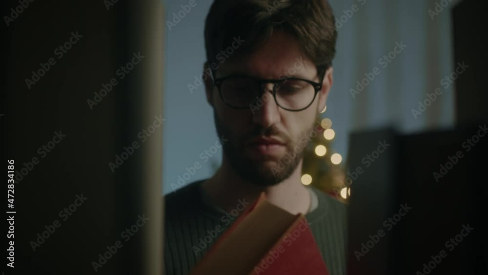 Giovane ragazzo prende libro dalla libreria in casa