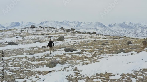 Adventurous man walking on a snow mountain. Bortala Valley in Xinjiang during winter. photo