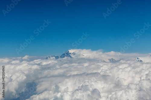 View at the Himalayas mountains and top of the Mount Everst above the clouds, seen from an airplane in Nepal