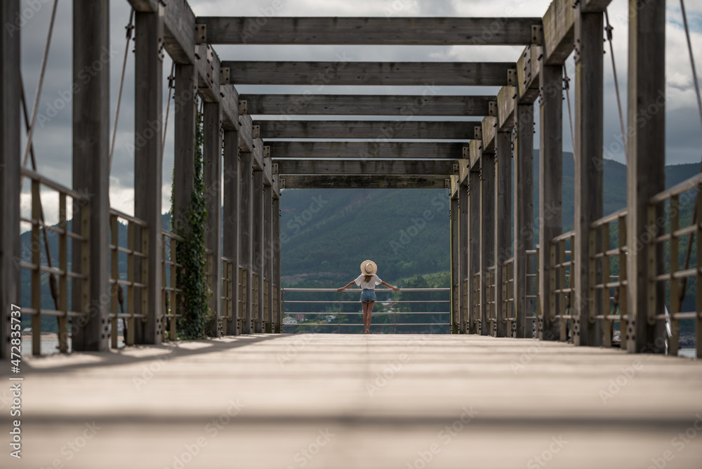 Female traveler on wooden pier near sea Female traveler on wooden pier near sea