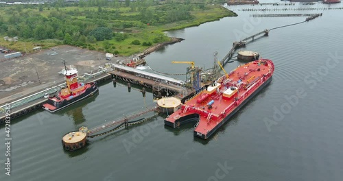 Red tanker ship unloading oil storage at industrial dock port import export petrol by tanker ship transportation, unloading oil platforms