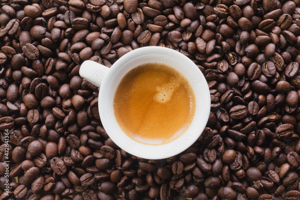 Macro view flat lays of coffee beans and a cup of coffee background Macro view flat lays of coffee beans and a cup of coffee background