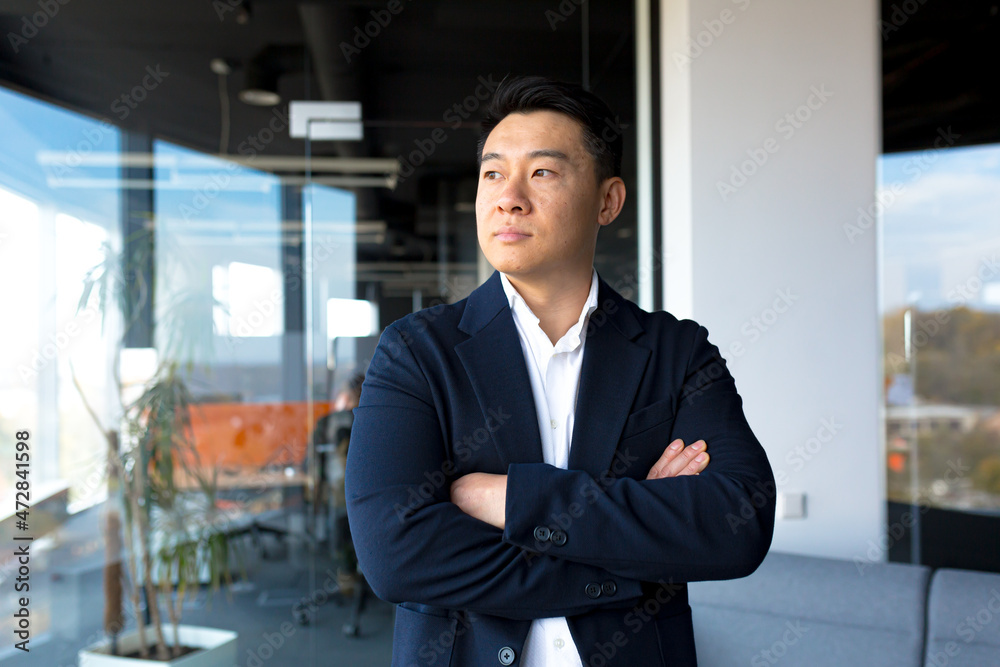 Fototapeta premium Portrait of successful business man boss Asian serious man looking at camera in modern office