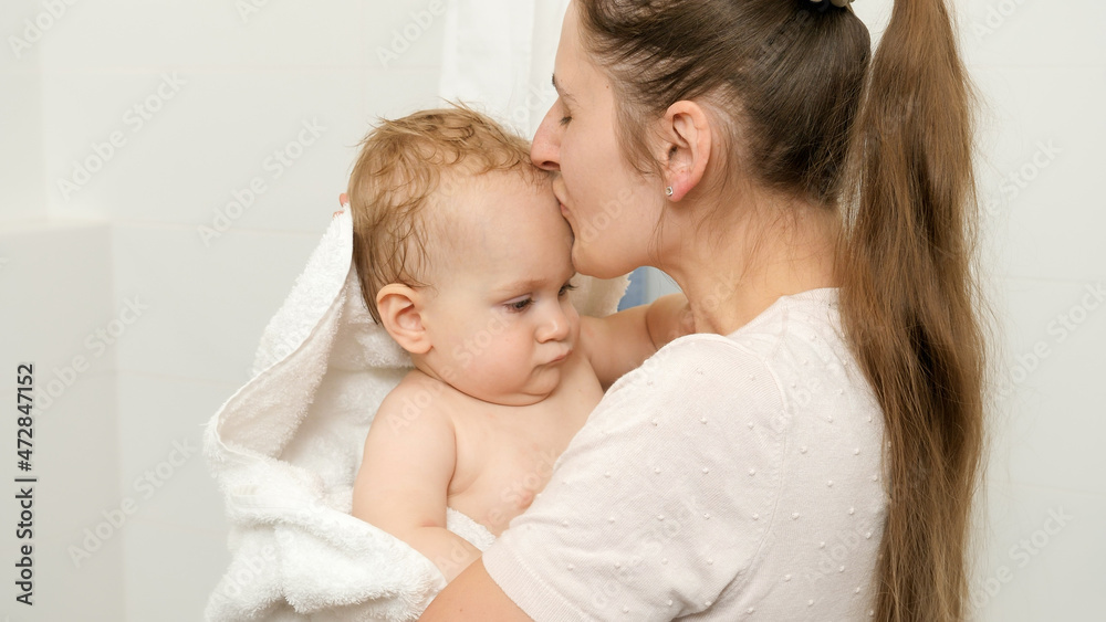 Loving mother kissing her baby son after washing in bath Loving mother kissing her baby son after washing in bath