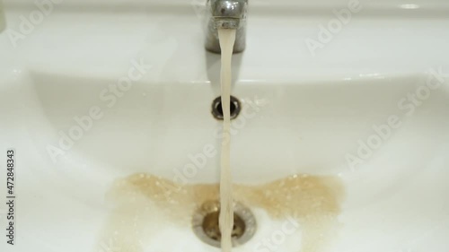 Dirty rusty water from the tap into