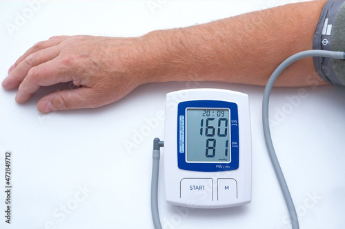 The doctor measures the patient's blood pressure. An elderly man has high blood pressure and pulse.