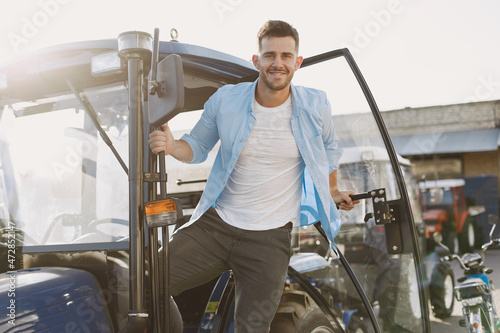 Male standing by the blue tractor