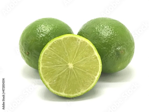 Two green Tahiti lemons from Brazil cut on white background.
