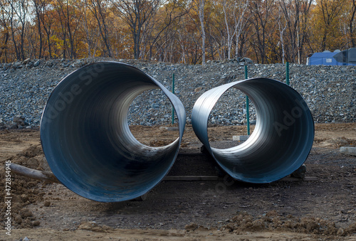 Large diameter metal pipes at a construction site.