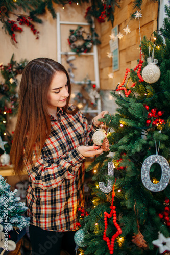 young woman holding an ornament and enjoying christmas and new year's atmosphere