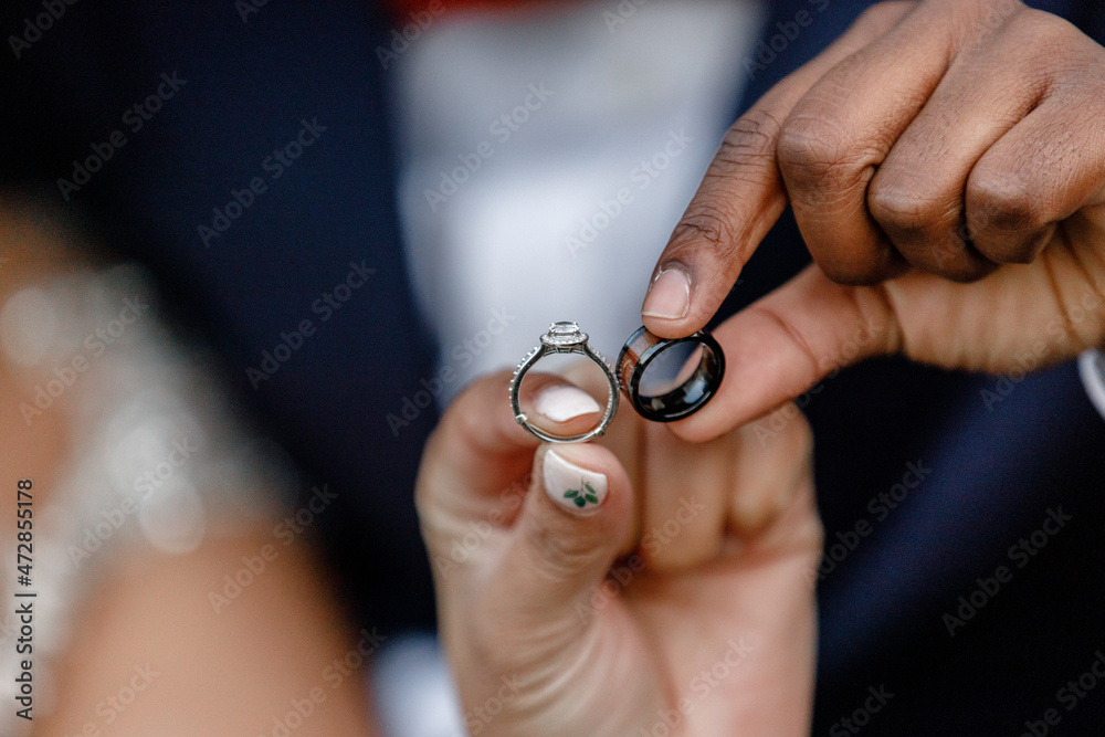The bride and groom are holding wedding rings with their own hands rings Close-up A newly married couple shows off their wedding rings Cropped photo Black and white wedding rings The bride and groom are holding wedding rings with their own hands rings Close-up A newly married couple shows off their wedding rings Cropped photo Black and white wedding rings