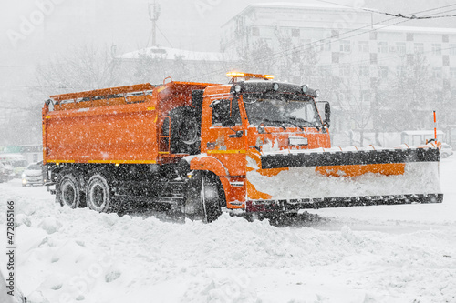 A large orange snowplow stands on the road before snow removal. Special equipment for snow removal cyclone.